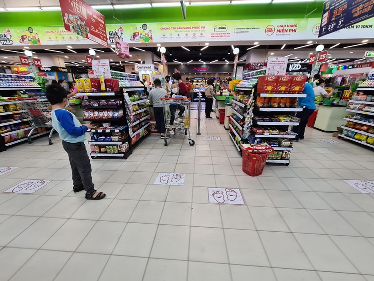 Siêu thị đánh dấu vị trí xếp hàng cho khách bằng hình in bàn chân nhằm giữ khoảng cách khi thanh toán để phòng, chống COVID-19.