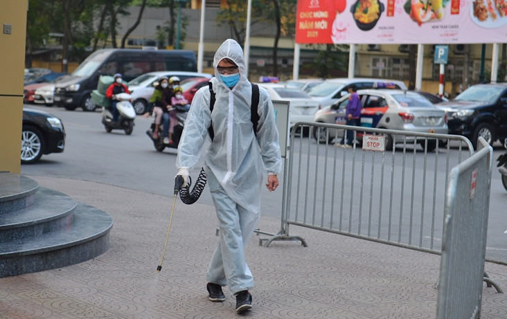 Từ ngày 27/1 đến 2/2/2021, bà V.H.H có đi làm tại ngân hàng. Ngày 3/2, bệnh nhân được Trung tâm Y tế quận Đống Đa lấy mẫu xét nghiệm; chuyển cách ly tại Tứ Hiệp, Thanh Trì, Hoàng Mai. Kết quả ngày 4/2 của CDC Hà Nội xác định người phụ nữ này dương tính với SARS-CoV-2. (Ảnh: Lực lượng chức năng phun khử khuẩn xung quanh ngân hàng Public Bank).