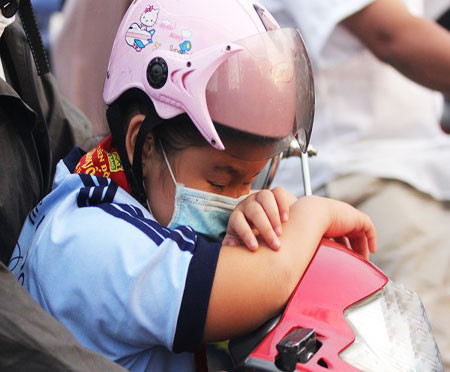 Những hình ảnh em bé ngủ gật trên xe máy khiến nhiều người đi đường không khỏi thót tim vì quá nguy hiểm. Ảnh: Vietnamnet.