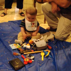 Theo nghi lễ truyền thống của người Armenia, đứa trẻ sẽ được bày xung quanh những đồ vật thông thường như tiền, dao kéo, cờ lê, bút lông, kinh thánh... Và sau đó các bé sẽ tự chọn một trong các món đồ đó. Ảnh: Pep.