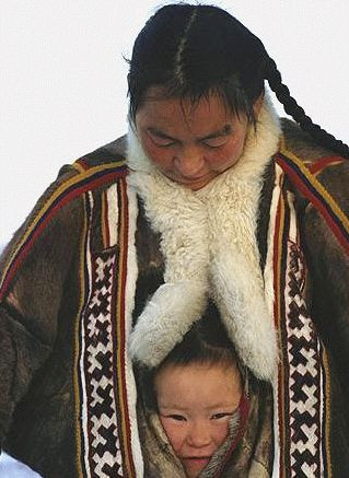 Một em nhỏ chống chọi cái lạnh bằng cách chui vào trong áo khoác của mẹ. Ảnh: Pinterest.