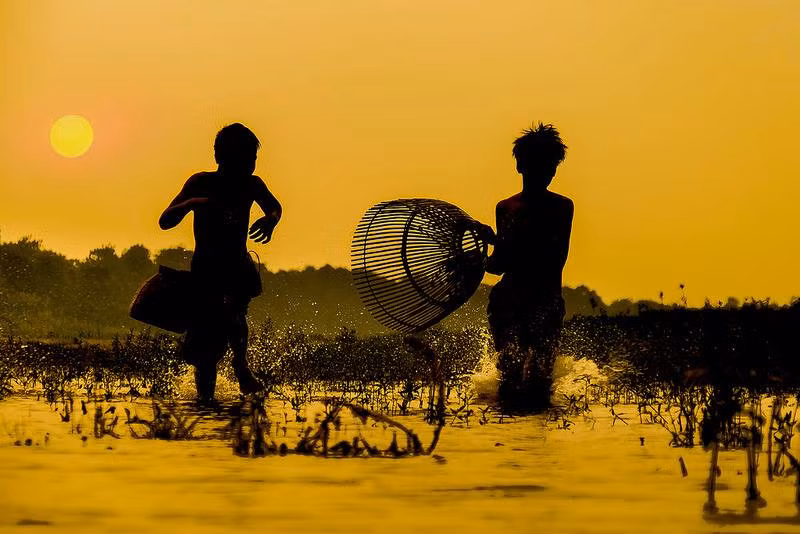 Nhiều đứa trẻ thích mò cua bắt ốc để bán kiếm tiền tiêu vặt hay thậm chí là... mang cho người khác. Đây đơn thuần là một việc "mua vui" chứ không phải là để "kiếm miếng ăn" như thời cha ông xưa kia. Ảnh: Hanoispanorama skylinegallery.