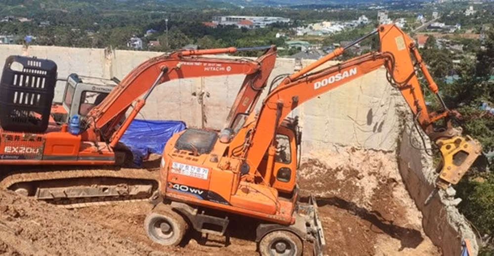 Ngay trong ngày nhận quyết định xử phạt, chủ đầu tư đã huy động 3 máy múc và nhiều công nhân tiến hành tháo dỡ bờ ta luy không phép. (Ảnh: Tiền Phong).