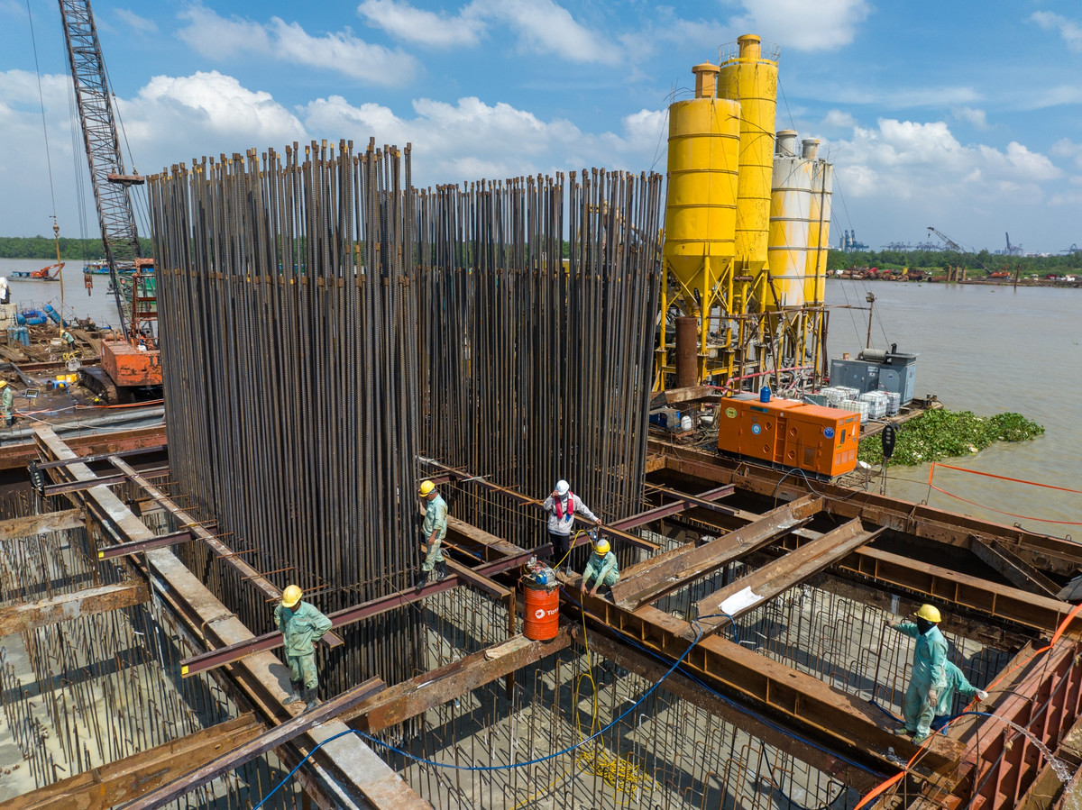 Những ngày đầu tháng 7, hàng chục công nhân, kỹ sư tất bật thi công các công đoạn đổ bê tông, đóng dầm, làm các lồng thép. (Ảnh: Giao thông).