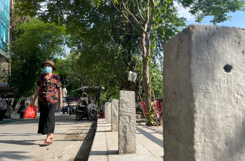 Nhiều đoạn vỉa hè ngõ Trung Tiền người đi bộ phải di chuyển dưới lòng đường để tránh các cọc bê tông xù xì.