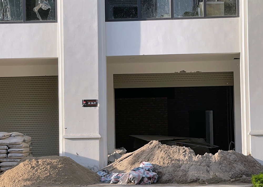 Vật liệu xây dựng chất đống trước một căn liền kề đang hoàn thiện.