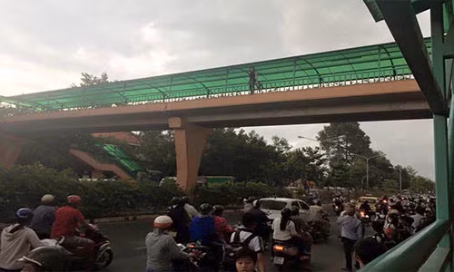 Cô gái trẻ đứng trên lan can cầu vượt bộ hành rồi sau đó nhảy xuống đường.