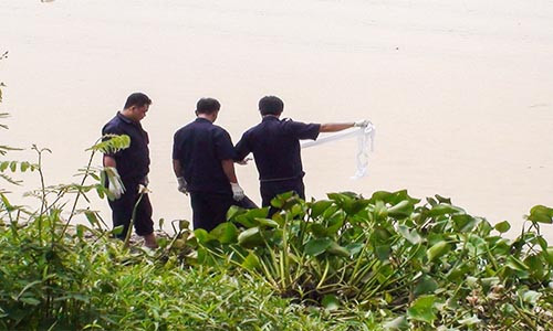 Cơ quan chức năng tiến hành trục vớt thi thể nạn nhân lên bờ.