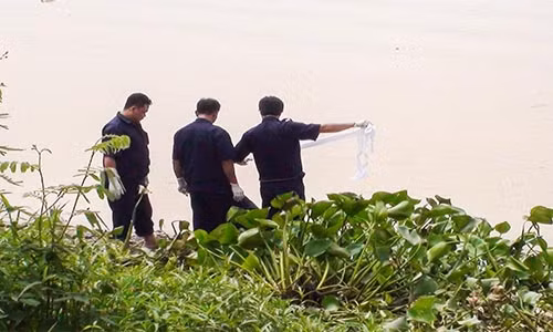 Cơ quan chức năng tiến hành trục vớt thi thể nạn nhân lên bờ.