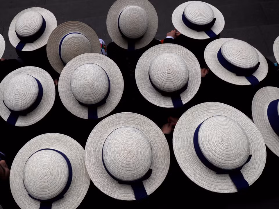 Học sinh Anh đội mũ cói rộng vành - một phần bộ đồng phục học sinh - khi tham quan bảo tàng V&amp;A ở thủ đô London.