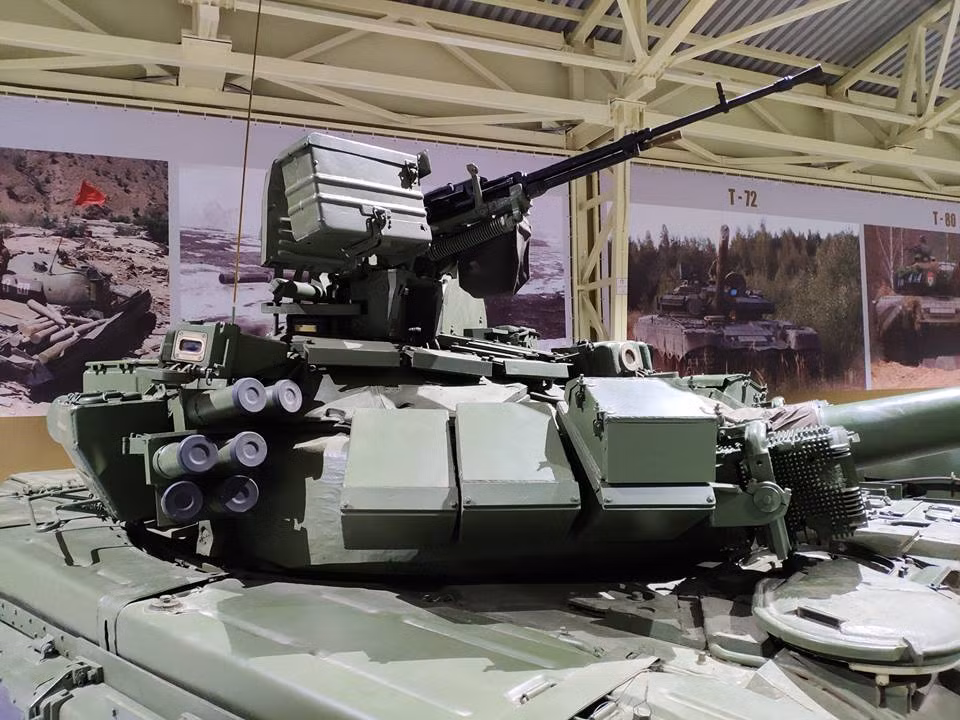 Bản thân T-90 cũng là dòng xe tăng đầu tiên trên thế giới được trang bị hệ thống phòng vệ chủ động - Shtora-1, với hệ thống này T-90 gần như miễn nhiễm với các loại tên lửa chống tăng dẫn đường thế hệ 1 hoặc 2. Biến thế nó trở thành “vua tăng” trong suốt 2 thập kỷ. Trong ảnh là đèn gây nhiễu OTShU-1-7 của Shtora-1. Nguồn ảnh: Vitaly Kuzmin.