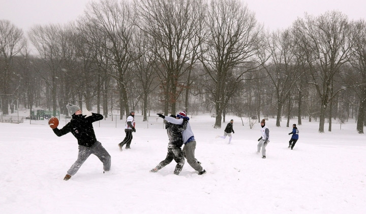 Bất chấp trời tuyết, nhiều người vẫn tham gia các hoạt động ngoài trời. Ảnh: Một nhóm thanh niên chơi bóng bầu dục trong công viên Cobbs ở New York.