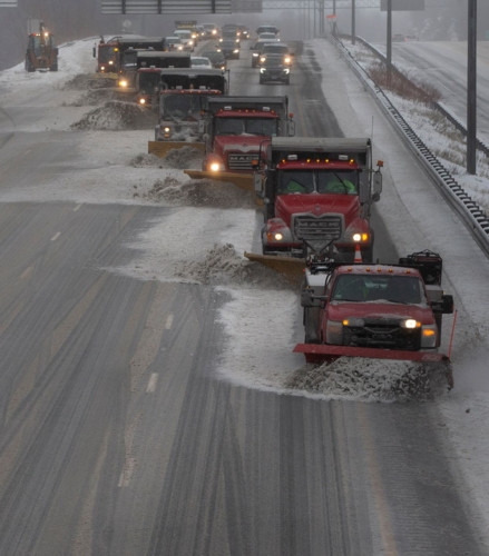 Một loạt xe dọn tuyết làm việc trên tuyến đường liên bang 93 ở Stoneham, Massachusette để đảm bảo giao thông.