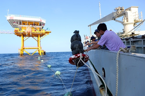 Nơi duy nhất mà đoàn có thể tiếp cận là Nhà giàn DK1/10 ở khu vực Bãi cạn Cà Mau nhờ quyết tâm của thủ trưởng đoàn công tác và nỗ lực phối hợp của thủy thủ tàu Trường Sa 19 với cán bộ nhà giàn. Ảnh: Thả hàng xuống biển.