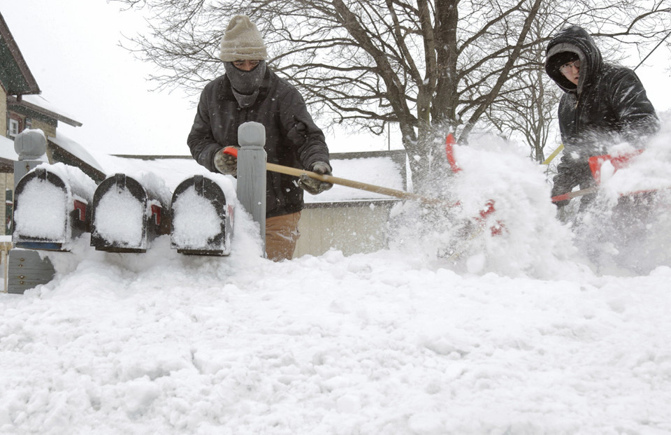 Ausencio Castaneda cùng con trai Ausencio Castaneda Jr. đào tuyết để tới được hòm thư của gia đình ở bang Wisconsin, ngày 28/1. Ảnh: AP.