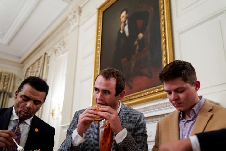 Các thành viên đội bóng đang ăn đồ ăn nhanh tại bữa tiệc.