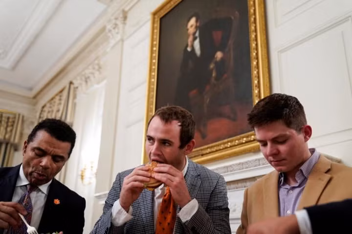 Các thành viên đội bóng đang ăn đồ ăn nhanh tại bữa tiệc.