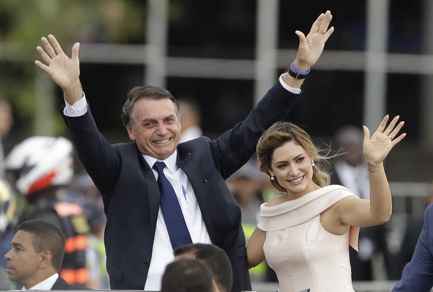 Tổng thống Jair Bolsonaro và phu nhân Michelle ngồi trên chiếc xe Rolls Royce mui trần sau lễ tuyên thệ ở Brasilia. Chiến thắng trong cuộc bầu cử của Bolsonaro đánh dấu bước chuyển mạnh mẽ sang cánh hữu đối với Brazil. Tân tổng thống cũng bày tỏ sự ủng hộ chế độ độc tài quân sự ở Brazil từ năm 1964 đến năm 1985. Ảnh: AP.