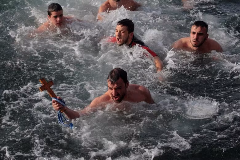 Michalis Apostolidis, 35 tuổi, bắt được cây thánh giá bằng gỗ trong Lễ Hiển Linh ở Thessaloniki, Hy Lạp. Theo truyền thống, người lấy được cây thánh giá bằng gỗ sẽ được giải thoát khỏi những linh hồn xấu xa và sẽ khỏe mạnh trong suốt cả năm. Sau khi thánh giá được vớt lên, linh mục sẽ dùng bó húng quế để rảy nước cho các tín đồ.