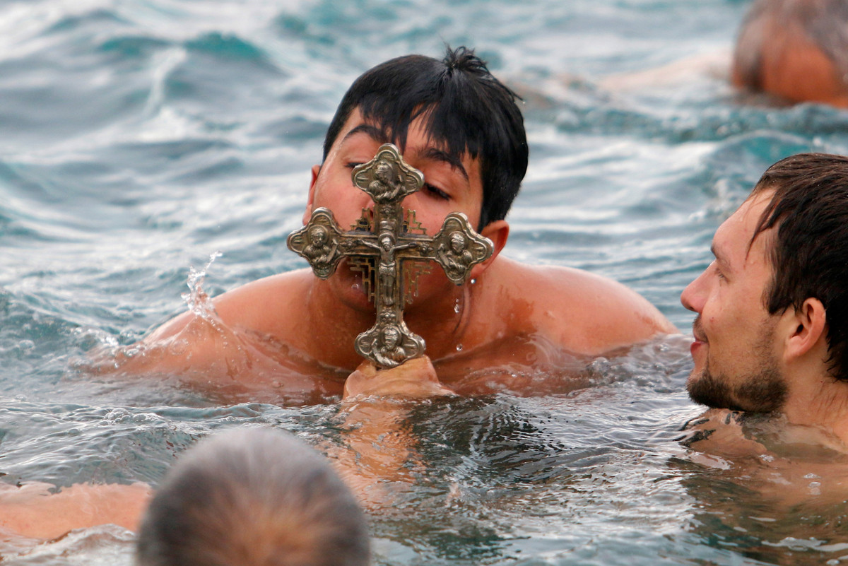Một tín đồ Chính thống giáo hôn cây thánh giá trong Lễ Hiển Linh ở phía bắc đảo Cyprus, Famagusta, Cyprus.