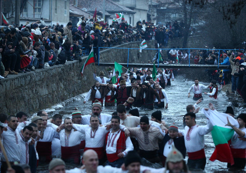 Nam giới nhảy múa trong vùng nước băng giá của sông Tnudzha trong Lễ Hiển Linh tại thị trấn Kalofer, Bulgaria. Tại thị trấn Kalofer, miền Trung của Bulgaria, hàng chục người đàn ông mặc áo thêu trắng lội xuống sông Tundzha vẫy cờ và hát những bài hát dân gian để mừng Lễ Hiển Linh. Bulgaria đã đề nghị UNESCO, cơ quan Văn hóa của Liên Hợp Quốc, công nhận truyền thống này là di sản văn hóa phi vật thể của nhân loại.