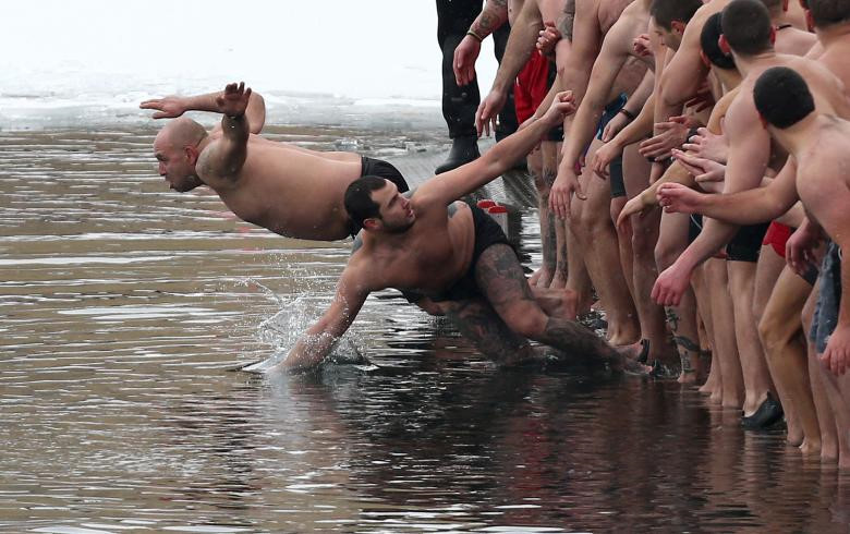 Đàn ông nhảy xuống hồ nước để tìm cây thánh giá gỗ trong Lễ Hiển Linh ở Sofia, Bulgaria.