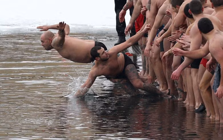 Đàn ông nhảy xuống hồ nước để tìm cây thánh giá gỗ trong Lễ Hiển Linh ở Sofia, Bulgaria.