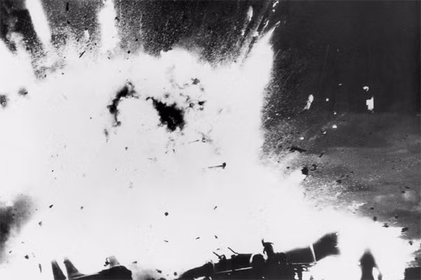 Theo kết quả điều tra sau này, vụ nổ đầu tiên đã làm thủng các thùng nhiên liệu của chiếc F-4J Phantom, làm bắn tung nhiên liệu máy bay JP-5 đang cháy lên các khoang thấp hơn của tàu. Ba phút sau, một quả bom gắn phía dưới chiến đấu cơ Phantom đang cháy rừng rực lửa nổ tung, tạo ra một lỗ thủng có diện tích gần 1m2 xuyên qua vỏ bọc thép của tàu.