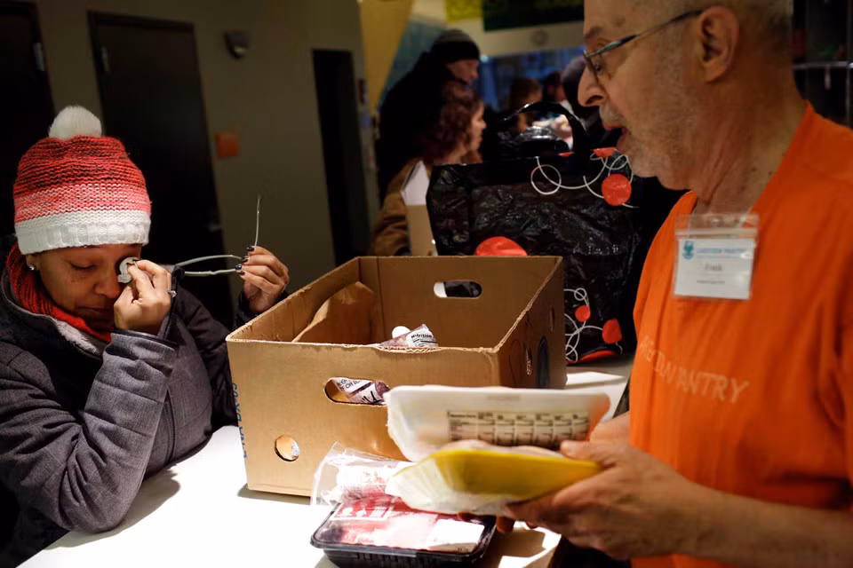 Ebony Grays, nhân viên Cơ quan An ninh Giao thông Vận tải (TSA), lau nước mắt sau khi nhận thức ăn tại Lakeview Pantry ở Chicago, Illinois, ngày 14/1. Khoảng 800.000 nhân viên liên bang đã nhận được giấy ghi nợ trong email thay vì tiền lương. Cả Hạ viện và Thượng viện đã bỏ phiếu để trả lại tiền cho tất cả nhân viên liên bang bị ảnh hưởng bởi việc đóng cửa. Nếu được ký kết thành luật thì tiền lương cho các viên chức sẽ được thanh toán một khi đạt được thỏa thuận ngân sách.