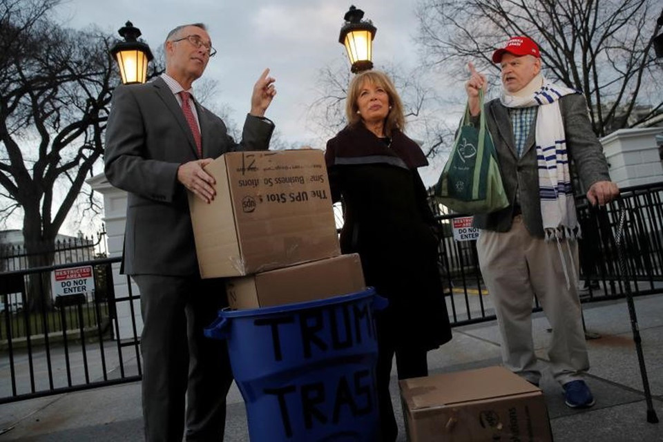 Hạ nghị sĩ Jared Huffman (trái) và Jackie Speier (giữa) nói chuyện với một người ủng hộ Tổng thống Donald Trump sau khi mang rác tới Nhà Trắng. Đây là những thùng rác họ thu thập được từ những địa điểm do liên bang điều hành đang không có nhân viên trong thời gian một phần hoạt động của chính phủ Mỹ bị tê liệt.