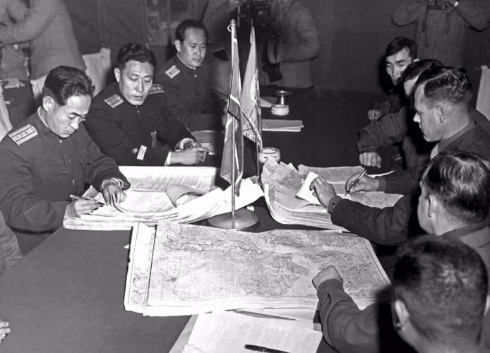 Đại tá James Murray Jr (phải) và Đại tá Chang Chun San của quân đội Triều Tiên với bút bi và những tấm bản đồ trong tay đã vẽ các đường biên giới hai miền Triều Tiên tại khu vực phi quân sự trong các cuộc thảo luận về thỏa thuận đình chiến Bàn Môn Điếm tháng 10/1951.