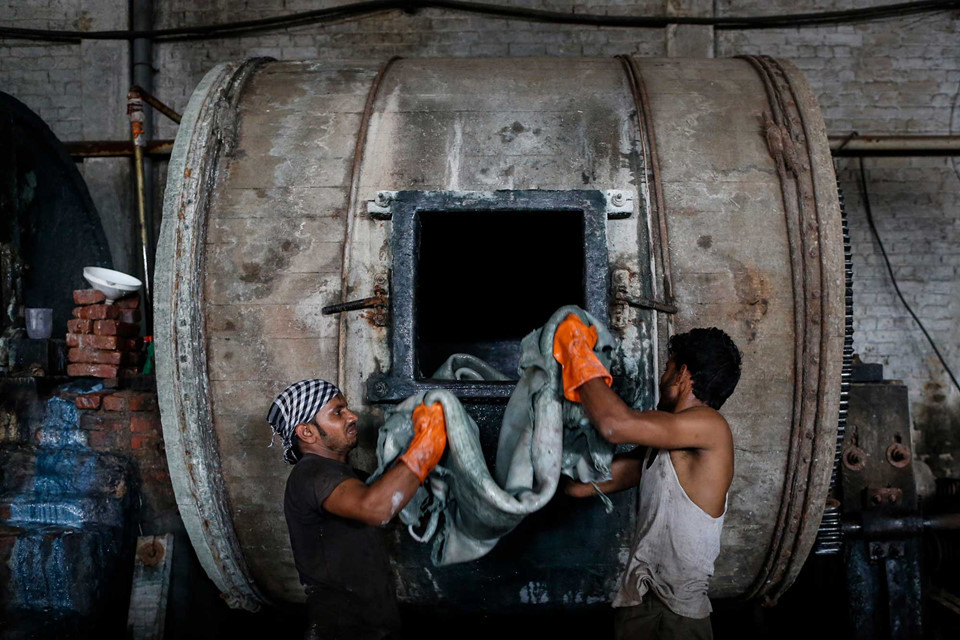 Các nhân viên nhét da trâu vào chiếc trống lớn bên trong xưởng thuộc da tại một khu công nghiệp ở Kanpur, Ấn Độ. Theo dữ liệu chính thức, chính quyền Thủ tướng Modi đã xóa bỏ việc xây dựng các nhà máy, đồng thời cải tạo các nhà máy hiện có với công suất kết hợp để làm sạch thêm hai tỷ lít nước thải mỗi ngày. Tuy nhiên, quy trình đấu thầu phức tạp đang khiến các nhà thầu không mặn mà với các dự án này.