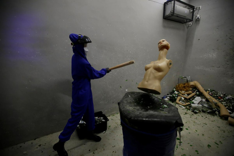 Một khách hàng nữ đập phá ma-nơ-canh trong "phòng xả giận"'. Theo những người sáng lập Smash, dịch vụ được mở không phải để thúc đẩy bạo lực mà nhằm giúp mọi người đối phó với những áp lực khi sống ở các thành phố lớn như Bắc Kinh.