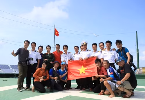 Đoàn công tác cùng cán bộ Nhà giàn DK1/10 chụp ảnh chung với lá cờ