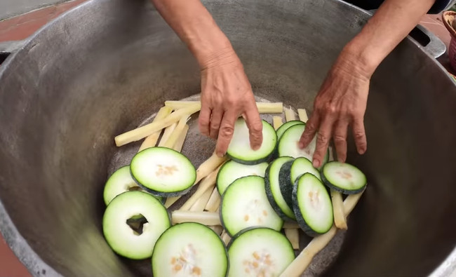 Sau khi thái xong, bà đổ hết vào nồi, những khúc bí được cắt ra vẫn còn dính nguyên phấn trắng. Chưa hết, nhìn bà Tân trộn hết nguyên liệu với nhau vào trong chiếc nồi to, nhiều người bày tỏ sự lo lắng không biết còn thứ gì bà chưa rửa nữa không.