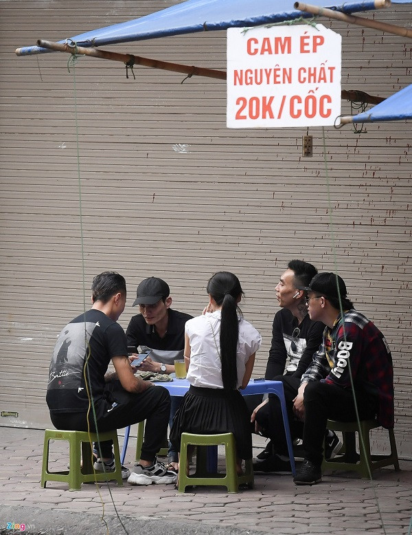 Trên phố Trung Phụng, một vài quán trà đá vẫn mở cửa. Khách hàng ngồi nói chuyện thành từng nhóm trên vỉa hè và không đeo khẩu trang.