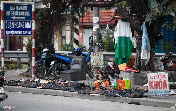 Nhiều hàng bán giày dép, mũ bảo hiểm trên vỉa hè đường Giải Phóng vẫn hoạt động bình thường. Cảnh tương tự cũng diễn ra trên phố Lê Đại Hành.