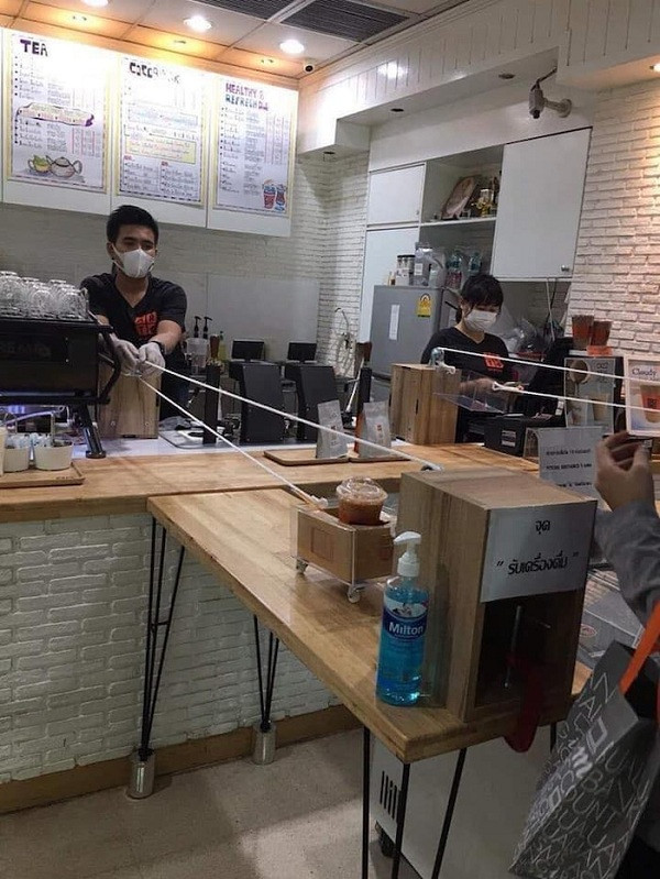 Dù đã mang khẩu trang và găng tay nhưng anh chàng nhân viên này vẫn cẩn thận đến mức sử dụng gậy giao đồ ăn cho khách qua 1 chiếc bàn dài.