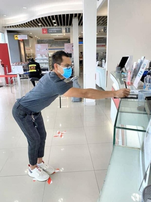 Dù đã đeo khẩu trang và mắt kính, anh chàng này vẫn hạn chế hết sức việc đứng gần người đối diện theo quy định.