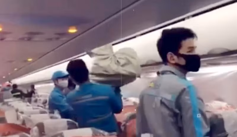 Cận cảnh cách nhân viên chuyển từng kiện hàng lên máy bay theo cách chuyền tay sau khi nhận kiện hàng từ cửa máy bay.