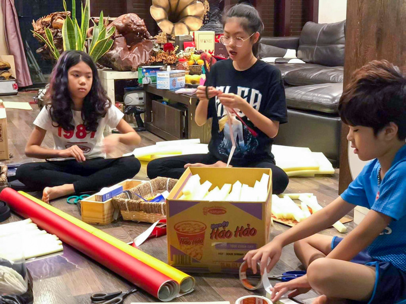 Các em lớn hướng dẫn các em nhỏ hơn, mỗi người phụ trách một công đoạn để làm một chiếc mặt nạ hoàn chỉnh.