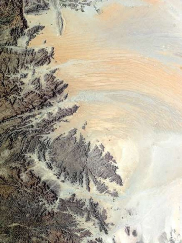 Hình ảnh chụp qua Trạm Vũ trụ Quốc tế (ISS) này cho thấy những đụn cát uốn quanh những ngọn đồi đá sẫm màu ở Yemen.