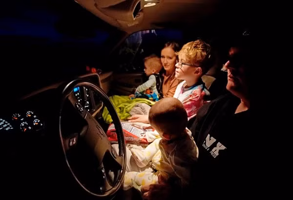 Một gia đình người Mỹ tận dụng khoảng không gian rộng rãi trong chiếc xe tải của họ làm nơi lý tưởng để xem phim, vừa ấm cúng vừa an toàn.