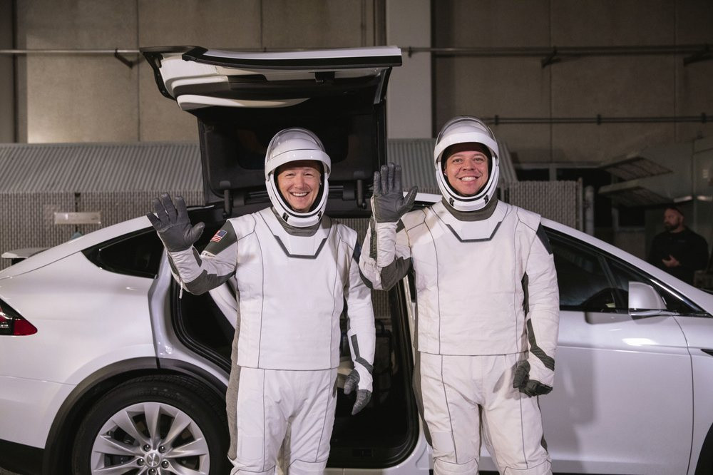 Những ý tưởng phía sau bộ trang phục của Doug Hurley và Bob Behnken xuất phát từ chính Elon Musk. Tỷ phú sở hữu SpaceX và Tesla cũng là một "fan cuồng" của khoa học viễn tưởng. Trong ảnh, hai phi hành gia Hurley và Behnken đứng bên mẫu ôtô điện Tesla Model X sẽ đưa họ đến bãi phóng.