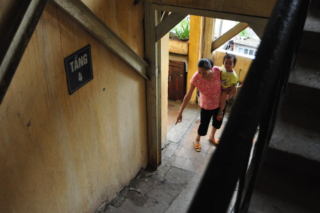 Phần mạch nối giữa cầu thang và tường chịu lực của khu nhà đang bị bóc tách tạo thành những vết nứt chạy dài từ tầng 1 lên đến tầng 5. Không còn cách nào khác, khu nhà đành phải chịu cảnh "chống nạng" chờ sập.