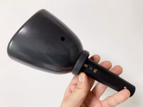 Nhìn từ bên ngoài, trông nó giống như một cái cốc có khả năng che kín miệng của người sử dụng, với một lớp cách âm phủ kín bên trong.