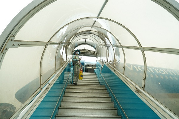 Khử trùng lan can, mui che ống lồng xe thang – vị trí hàng trăm khách tiếp xúc trên chuyến bay mỗi ngày.