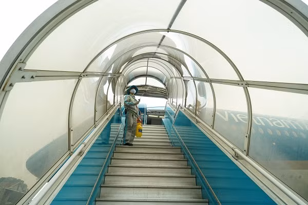 Khử trùng lan can, mui che ống lồng xe thang – vị trí hàng trăm khách tiếp xúc trên chuyến bay mỗi ngày.