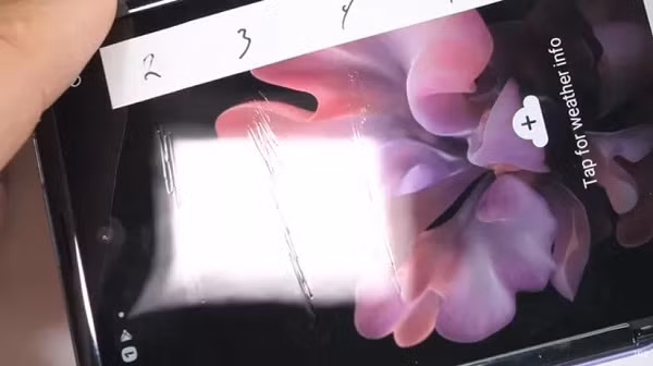 Sự cố trên đã thu hút sự quan tâm của các tín đồ công nghệ, và YouTuber Zack Nelson của kênh JerryRigEverything là một trong số những người đặt ra nhiều nghi vấn về chất lượng kính của Samsung Galaxy Z Flip. Sau màn “tra tấn” của mình đối với chiếc smartphone này để kiểm tra độ trầy xước, và biến dạng khi làm nóng, Nelson nghi ngờ rằng, kính UTG của Galaxy Z Flip không thực sự là kính mà chỉ là nhựa trộn bột thủy tinh. Ảnh: chụp màn hình