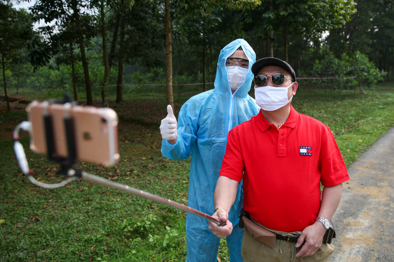 Một người dân trong diện cách ly thích thú chụp ảnh selfie với nhân viên y tế tại khu cách ly.